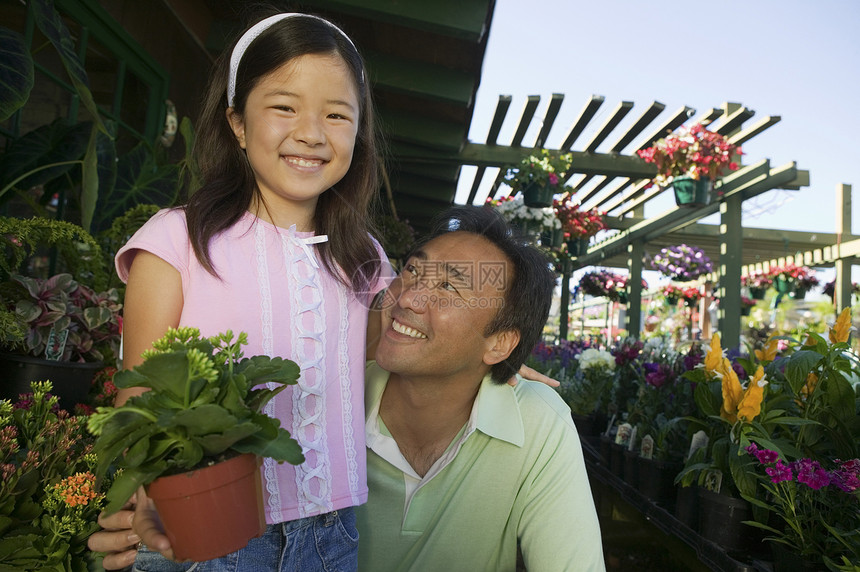 父亲和女儿在植物苗圃肖像中图片