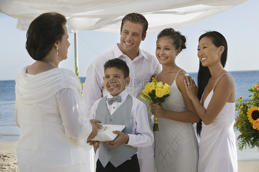 与家人在海滩婚礼上的新娘和Groom图片