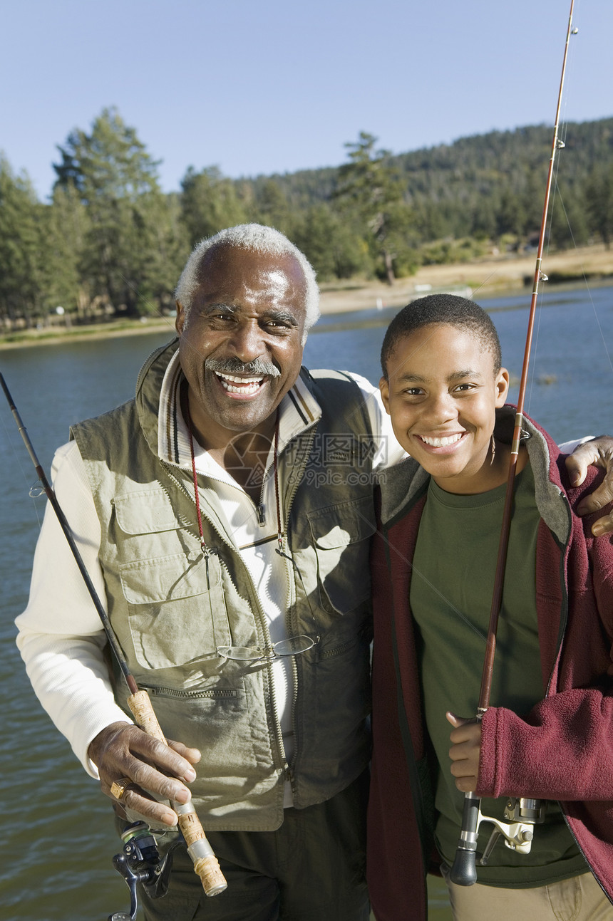 在阳光明媚的一天 带着孙子钓鱼的快乐老人的肖像图片
