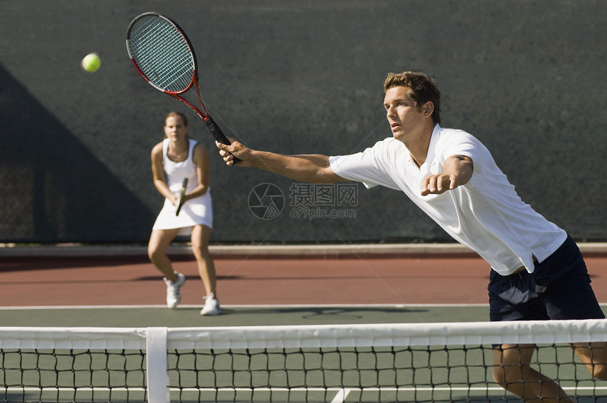 双人球手在法庭上用近网前针打网球的景象图片