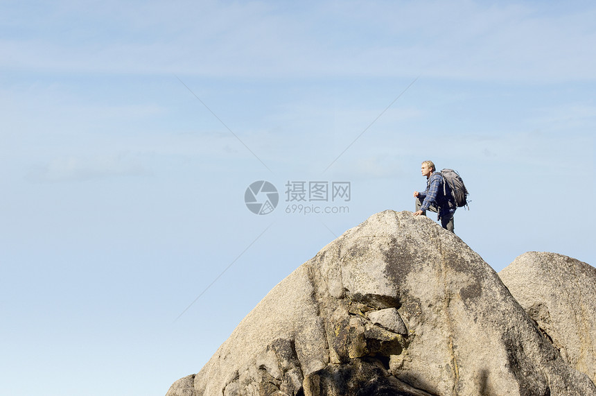 山顶男性登山者的侧视角图片