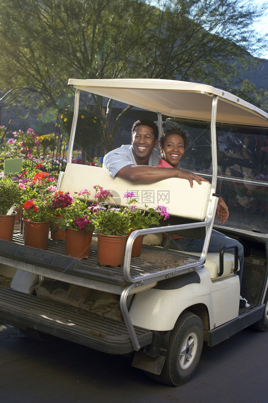 在植物园高尔夫车里快乐的非裔美国夫妇图片