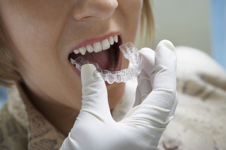 缝合牙医的手贴塑料牙套图片