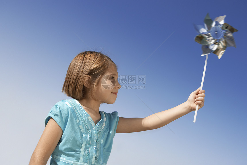 小女孩玩针轮玩具 在晴天上飞翔图片