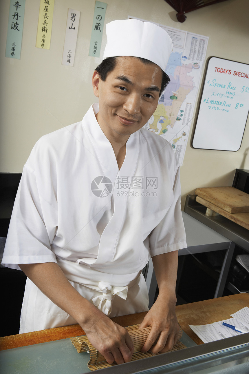 一位在餐厅做饭的亚洲厨师的肖像图片