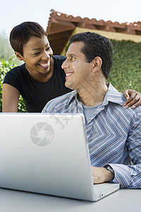 与使用笔记本电脑的成熟男子相爱异性恋夫妇高清图片素材