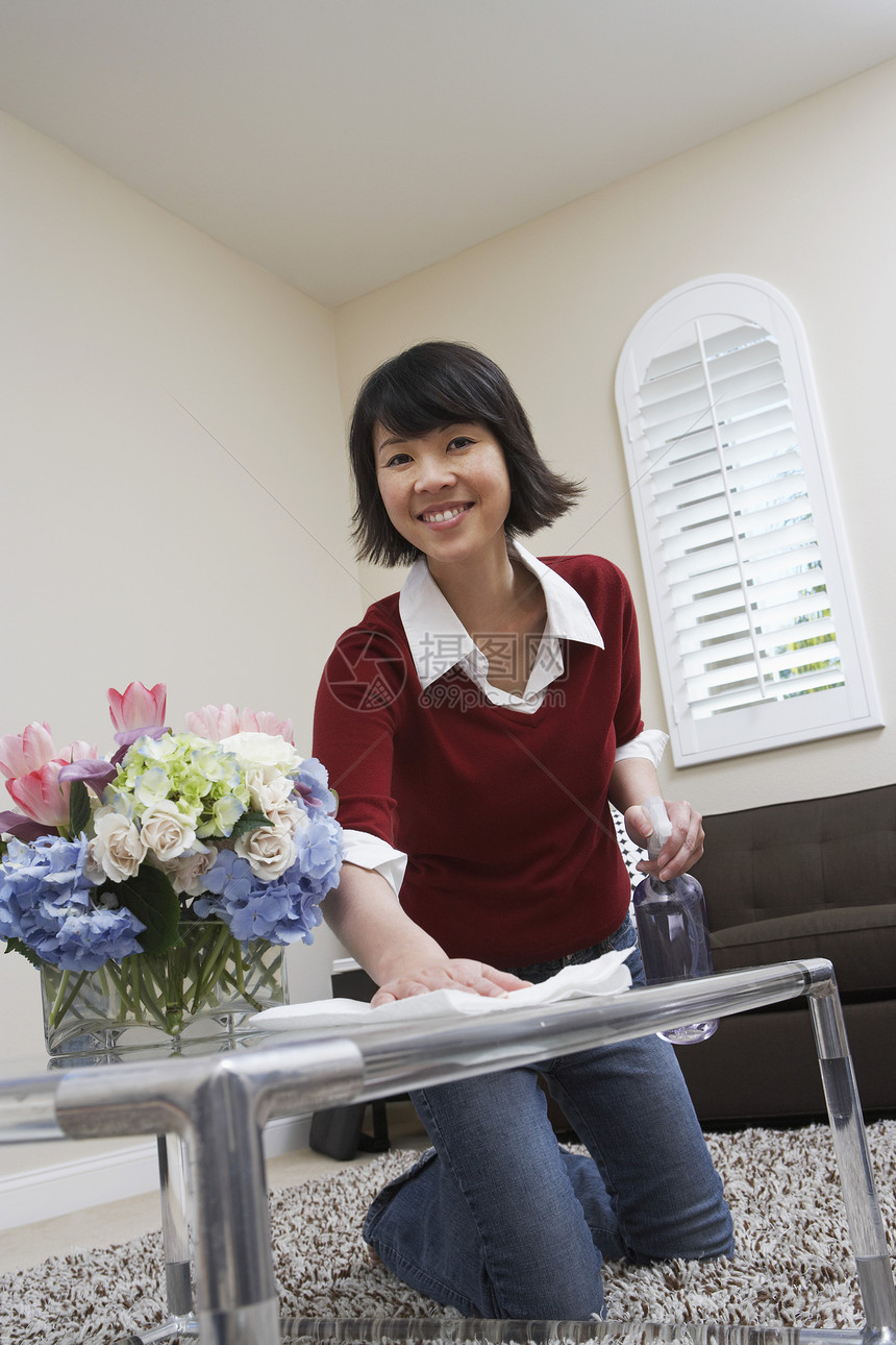 一名亚洲女性在家打扫桌的肖像图片
