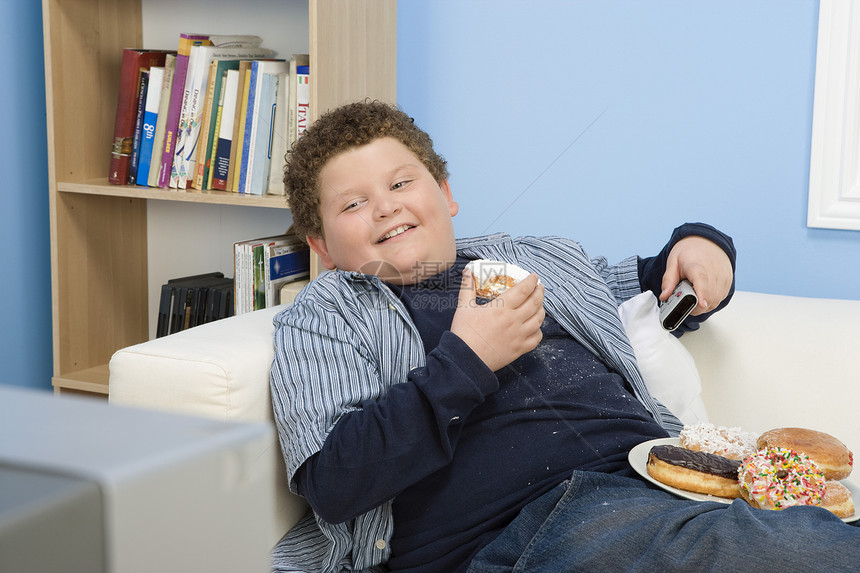 玩耍吃甜甜圈电视遥控肥胖土豆食物糖果青春期电视机摄影男生图片
