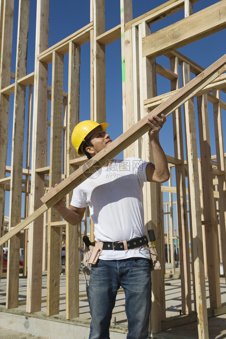 硬干建筑工人将木板停在工地建筑劳动进步头盔材料服装专注安全帽中年男子图片