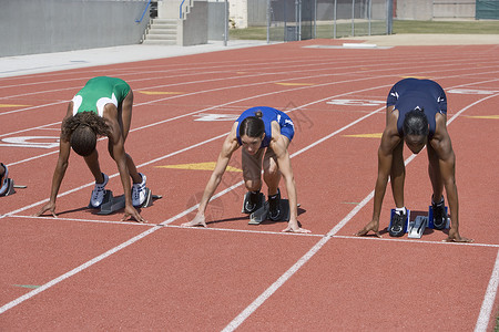 多族裔女运动员在赛道上起跑线的多种族女子运动员背景图片