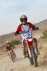 带儿子的女摩托车越野赛骑手在赛道上骑摩托车背景图片