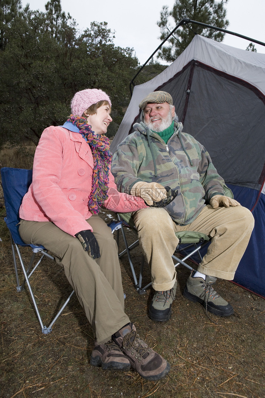 一对恩爱的老夫妇坐在露营帐篷前的椅子上图片