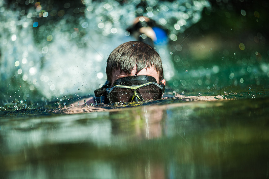 年轻成人在河流中潜伏潜水员蓝色男性游泳者假期套装闲暇男人面具浮潜图片