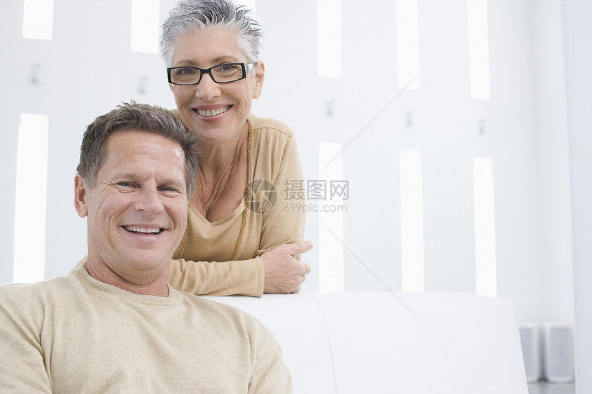 快乐的成熟情侣在客厅休息的肖像眼镜婴儿潮水平夫妻微笑女士团结男人成人房子图片