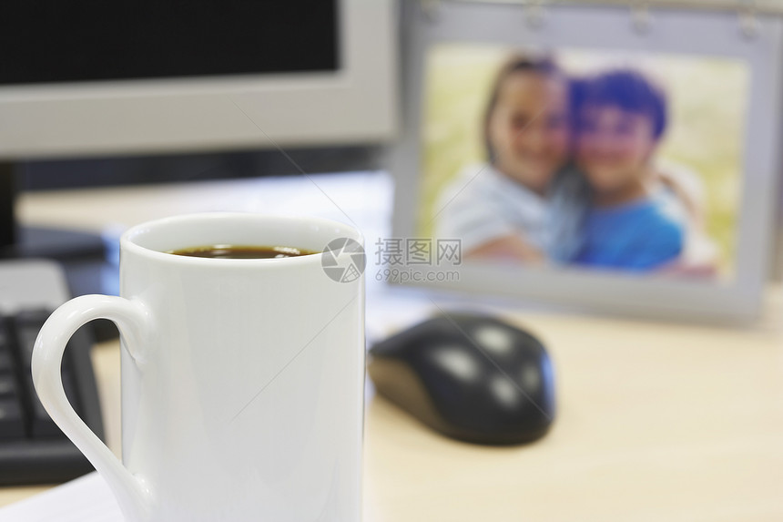 咖啡杯在桌上 有家庭背景照片图片