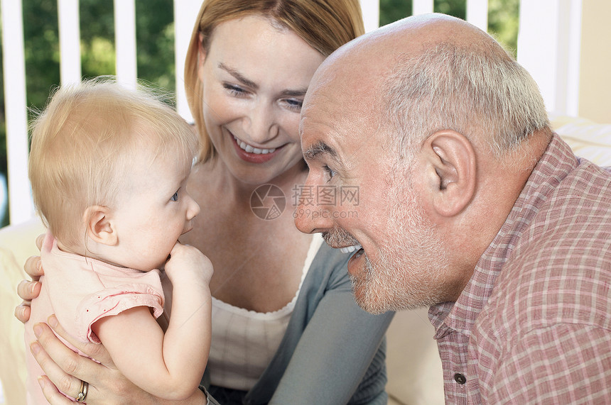 一个快乐的祖父母与女儿和孙女的近亲图片