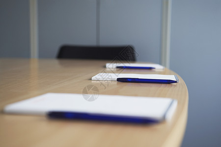 会议桌上注纸和笔记板的选择性重点背景图片
