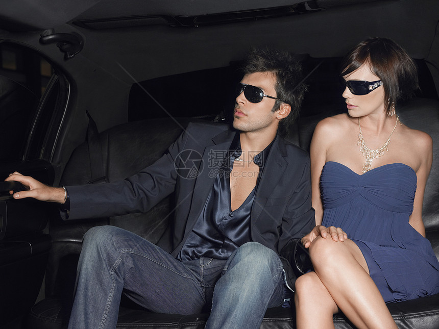 穿着豪华轿车墨镜的年轻迷人夫妇图片
