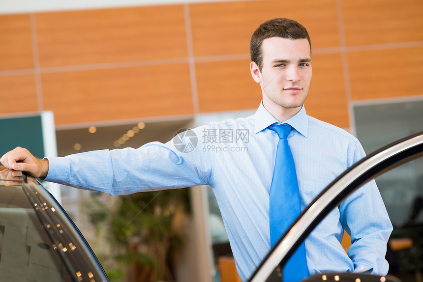 交易商站在新车旁边的展厅里品牌运输女孩司机蓝色代理人购物协议通勤者手臂图片