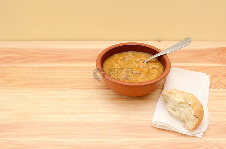 豆腐蔬菜汤和半块面包卷的图片