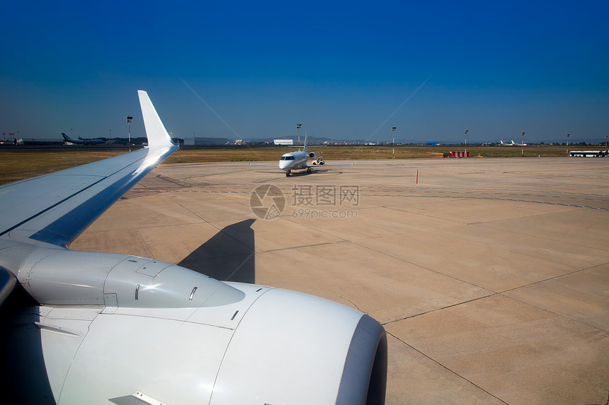 飞机机翼在机场有飞机背景蓝色运输飞机场季节阳光地平线天空翅膀涡轮天气图片