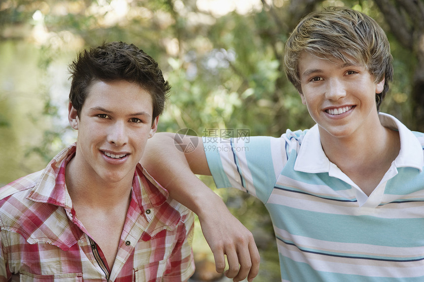 两个十几岁的男孩在森林中微笑的肖像图片