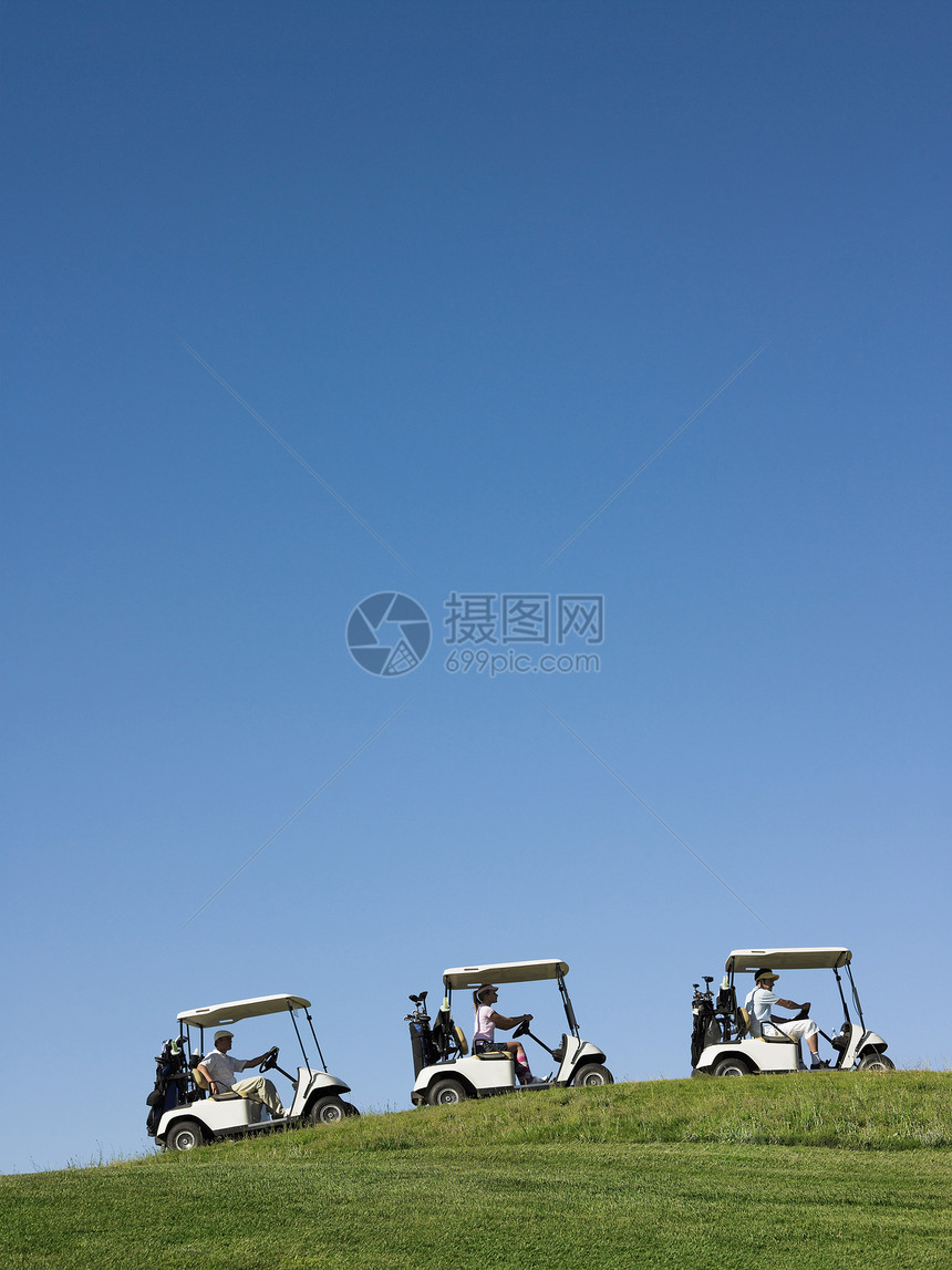 高尔夫车在蓝色的天空中排行驾驶推车上坡娱乐播放器游戏运输成人男士运动课程男性图片