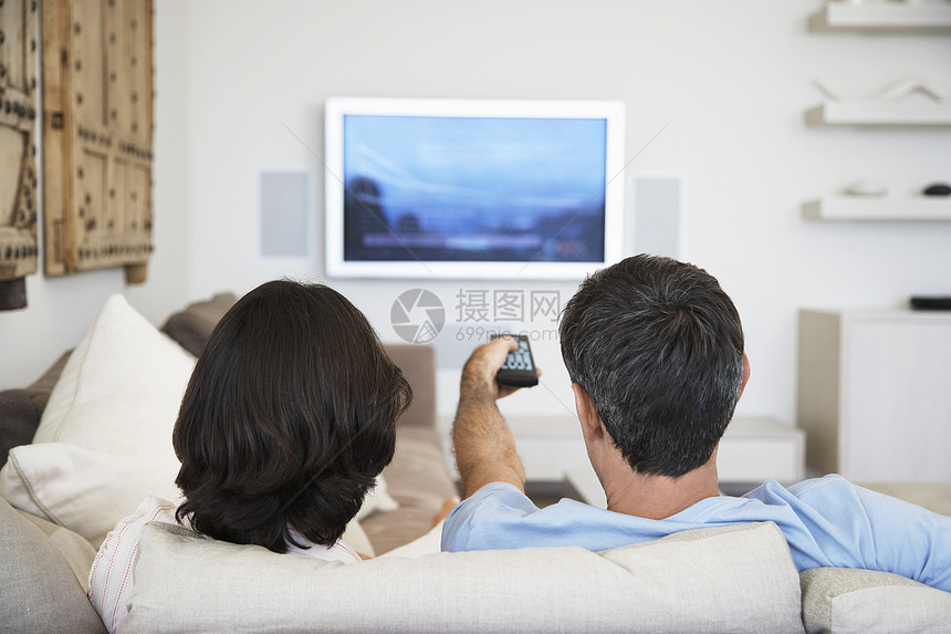 一对夫妇在客厅看电视的近视男性闲暇女士水平男人沙发技术婴儿电视夫妻图片