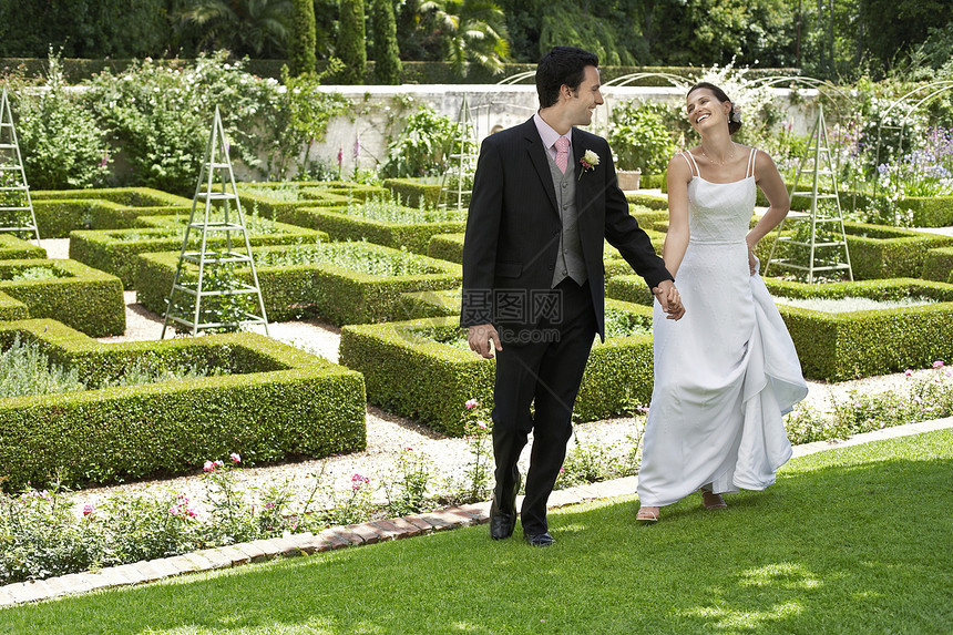 整个快乐的新娘和新郎在公园散步图片