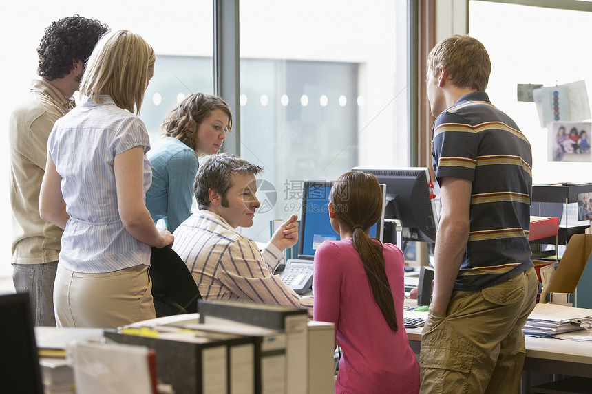 使用计算机背视图在同事周围站着的办公室工作人员群人男子窗户中年上班族团队商业桌子服装中年人图片