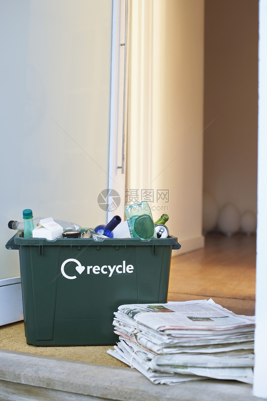 特写回收容器和地板上堆积的废纸垃圾图片