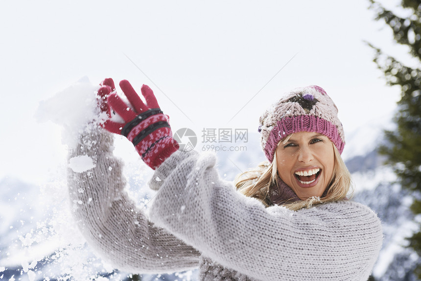 一位快乐的年轻女子捕雪球的肖像图片