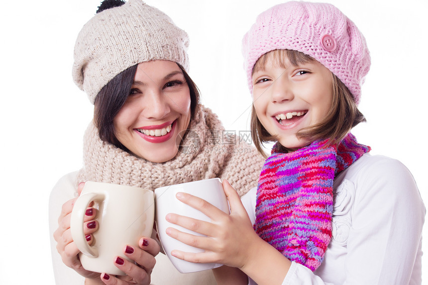 带着热饮的编织帽子的母亲和女儿快乐家庭父母咖啡黑发女性女孩们可可饮料食物青少年图片