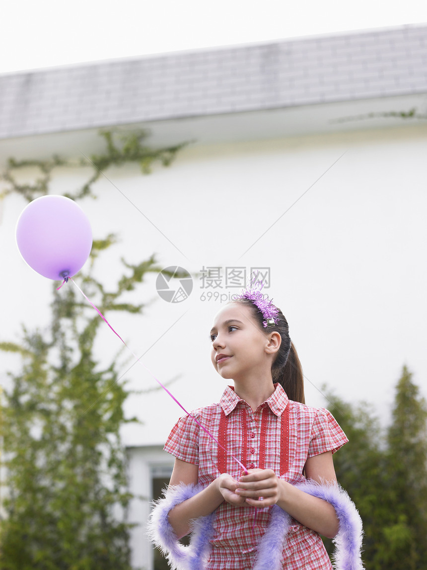 戴头冠和羽毛胸罩气球的可爱女孩图片