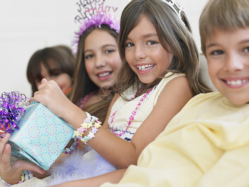 在生日派对上坐在一排的笑笑儿童近亲照片闲暇团体乐趣女孩享受朋友们皇冠童年喜悦盒子图片