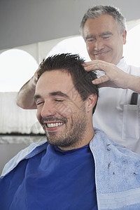 开心男人理发后去理发师按摩头部毛巾高清图片素材