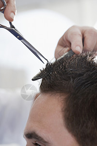 男人在沙龙理发店剪头发的近身修剪高清图片素材