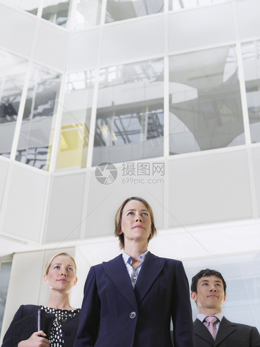 三名信心企业人士在办公大楼楼顶站立的低角度视角观点较低者图片