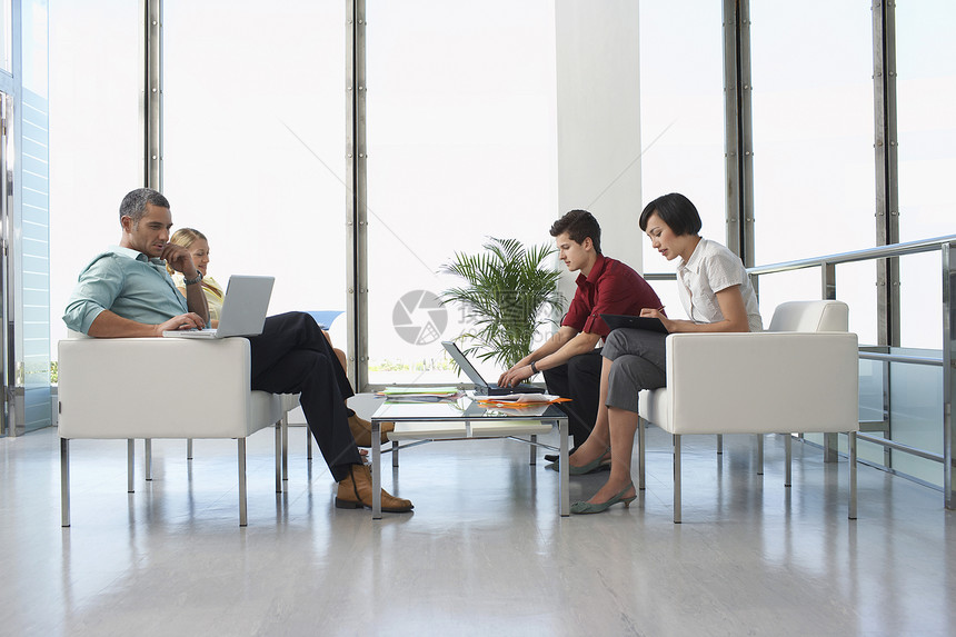 坐在办公室现代候诊室的四名商界人士的全长侧视线盆栽扶手椅窗户房间座位接待技术休息室成人植物图片