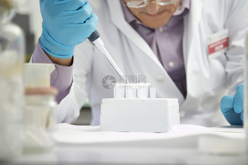 特写实验室内装有管道管的男性科学家填充试验管手套测量实验知识技术腹部化工标本吸管器皿图片