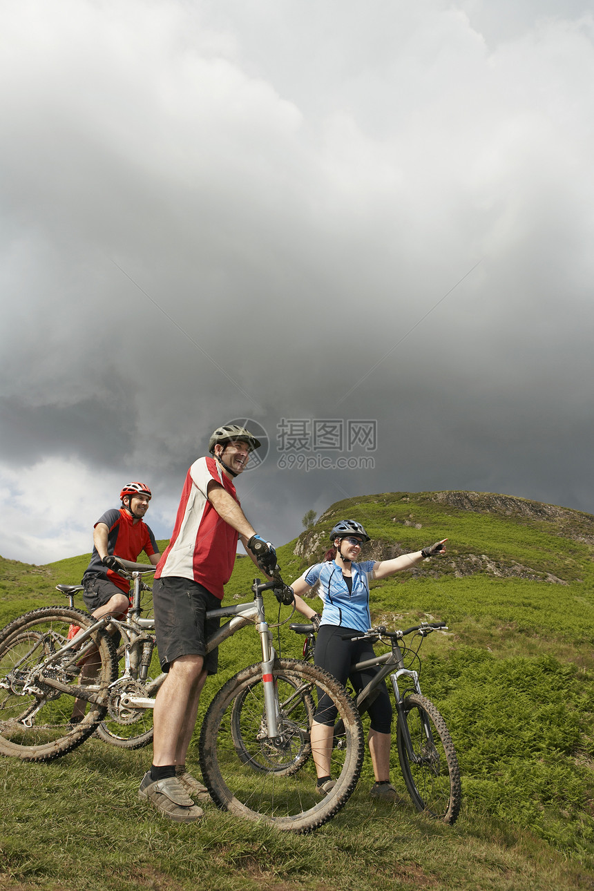 山坡上三个骑自行车的人图片