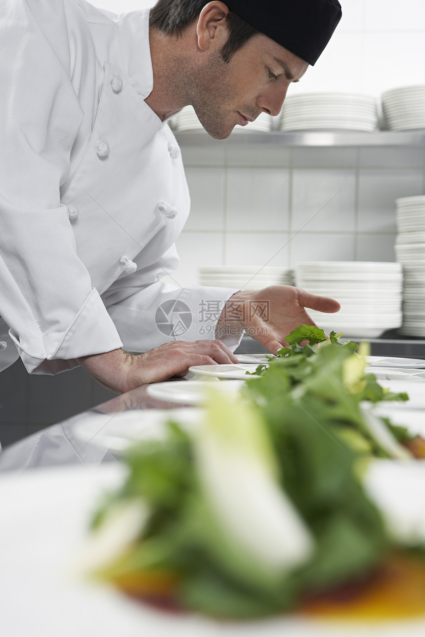 厨房准备沙拉的男厨师侧面观职业食物双手男性成人商业专注餐厅绿色盘子图片