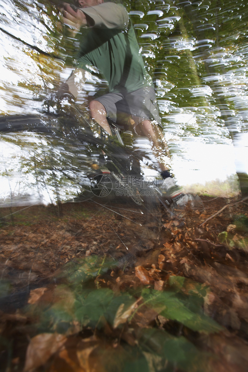 人类在森林中骑着山上自行车的模糊运动骑术男人男性森林运输闲暇叶子活动娱乐速度图片