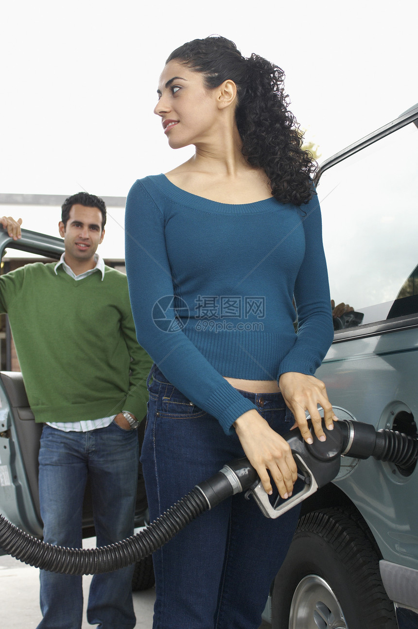 青年多族裔夫妇在加油站加油车加油车图片