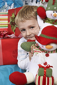 一个快乐的小男孩 拿着填满的雪人肖像背景图片