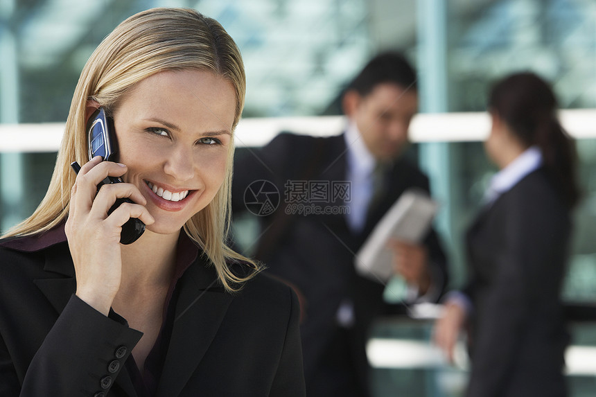 与背景同事使用手机的快乐商业女商务人士肖像 照片来自Flickr用户图片