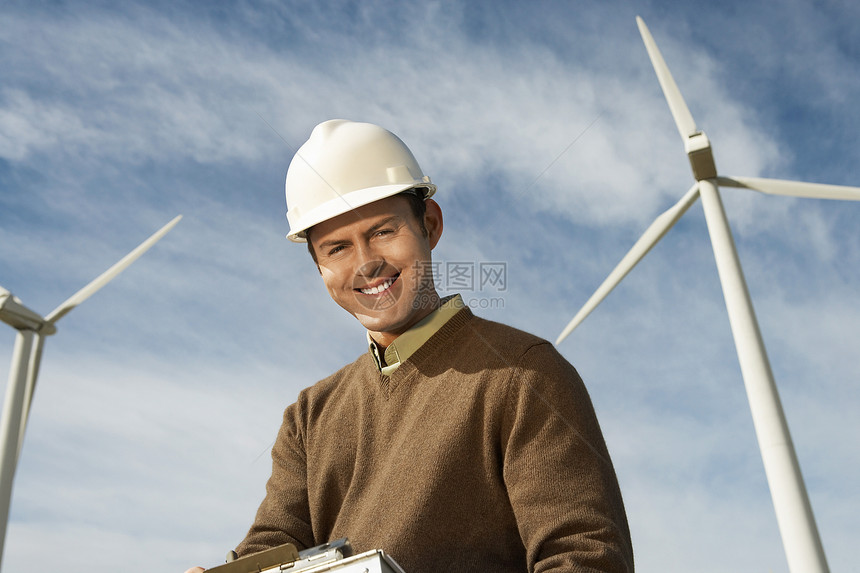 在风力农场工作的一位快乐的男性工程师的肖像图片