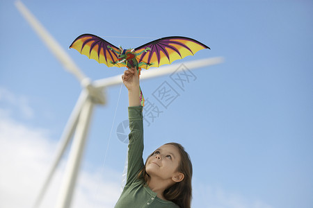 小白种女孩在风力农场玩龙风筝背景