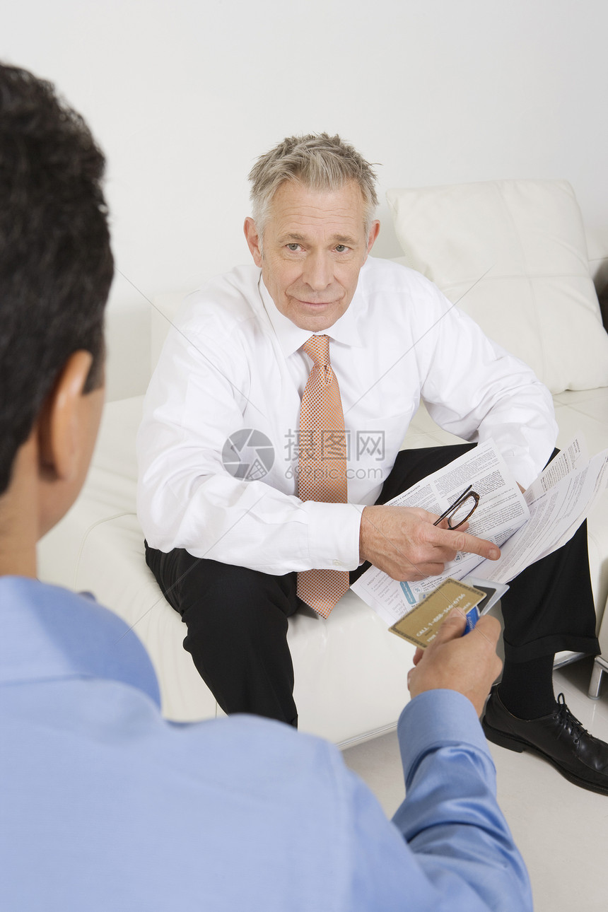 高级商务人士用信用卡协助男子的高级商务人士图片