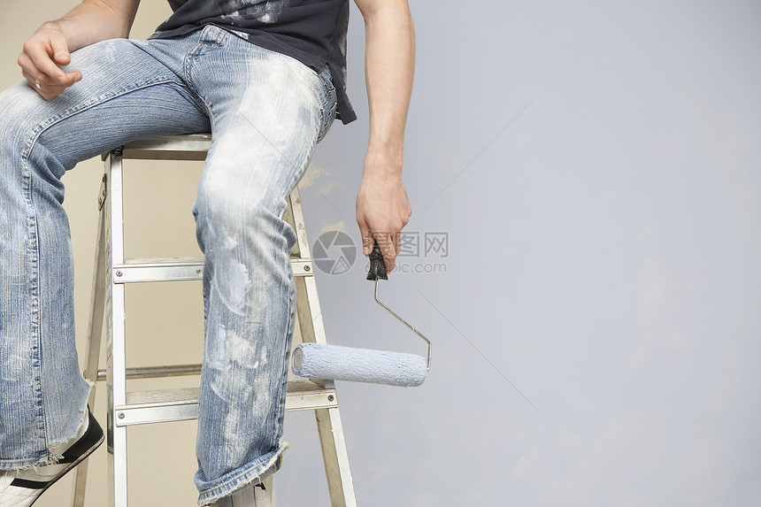 坐在扶梯上靠墙站着时拿着彩画的人的中流体图片